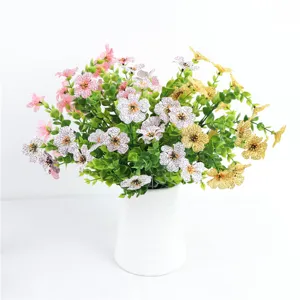 Vista dettagliata di fiori di seta viola artificiali con foglie di eucalipto in vaso di ceramica.