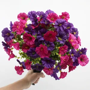 Close-up detail of artificial morning glory bouquet with purple and pink flowers and green leaves.