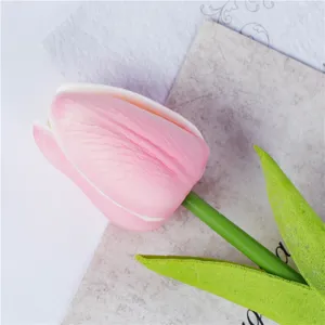 Nahaufnahme der Textur von künstlichen rosa PU-Tulpenblütenblättern und grünem Stiel.