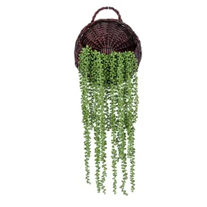 Artificial string of pearls hanging plant in wicker basket for wall decor detail.