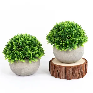 Detailed view of the artificial green potted plants set, featuring mini round grey paper pots.