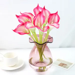 Vue détaillée de fleurs de lys calla artificielles, matière PU toucher réel en vase rose.