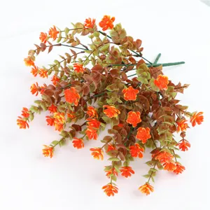 Dettaglio ramo di eucalipto artificiale, foglie autunnali e fiori arancioni per decoro.
