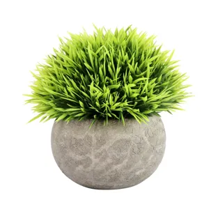Artificial potted plant faux green grass in grey textured pot for home indoor decor.