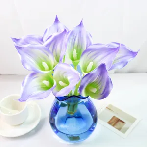 Magnifique bouquet de fleurs de lys calla artificielles avec vase en verre bleu.