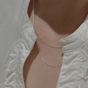 Detail shot of S925 sterling silver layered snake bone necklace, minimalist chic design.
