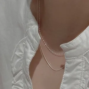 Close-up of minimalist double-layered sterling silver snake bone chain necklace for women fashion.
