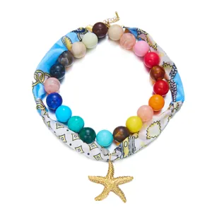 Primer plano detallado del collar de cuentas de colores con pañuelo de seda y estrella.