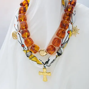 Collar de cuentas de ámbar de doble capa con pañuelo de seda y colgante cruz dorada.