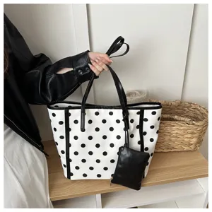 Elegante borsa a tracolla da donna a pois bianchi e neri, grande capienza e stile.
