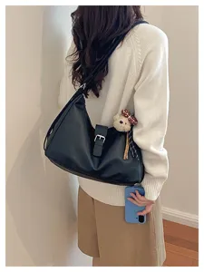 Gedetailleerd zicht op Koreaanse retro zwarte schoudertas, stijlvolle hobo tas met berenhanger.