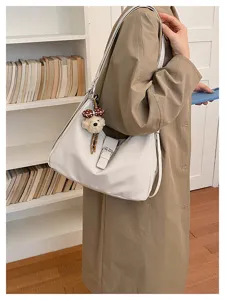 Gedetailleerd overzicht van casual koreaanse retro witte leren schoudertas met schattige berenhanger.
