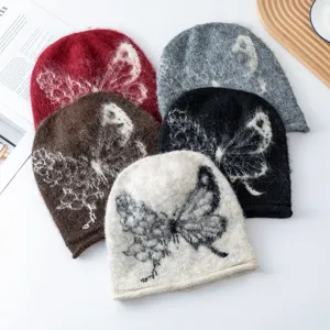 Close-up detail of cozy fuzzy knit beanie with vintage butterfly pattern in multi colors.