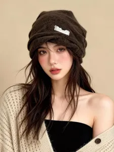 Detalle gorro punto plisado marrón, diseño slouchy cálido, accesorio otoño invierno acogedor.