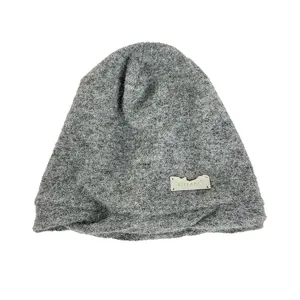 Vista detallada del gorro de punto gris con una etiqueta metálica de la marca.