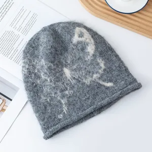 Close-up of cozy gray knitted beanie featuring a retro butterfly pattern and soft wool texture.
