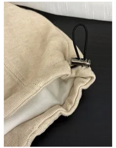 Detail shot of vintage slouchy beanie hat featuring adjustable elastic drawstring and metal cord lock.
