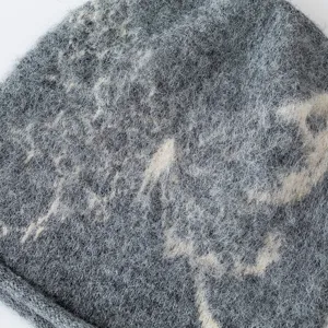 Grey knit slouchy beanie detail, soft furry texture with retro butterfly pattern, warm winter wool cap.