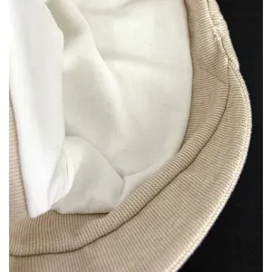 Detail view of the beige knit beanie showcasing the soft inner lining and ribbed brim texture.