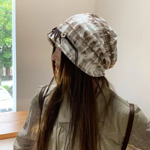 Ethische Batik Slouchy Mütze mit Quasten und Holzblumen-Dekor, retro Herbst Mode Beanie Stil.