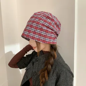 Primer plano del sombrero plisado de cuadros rojos que muestra textura y caída elegante.