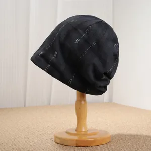 Detailansicht der schwarzen Beanie mit Buchstaben-Print, modische lässige Damen-Strickmütze.