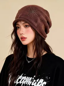 Gros plan détaillé d'un bonnet slouchy en tricot lavé marron avec motif d'étoile en strass.