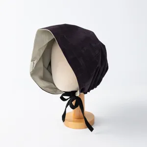 Detailaufnahme der stilvollen wendbaren Karohaube mit Stofftextur und feinem Innenfutter.