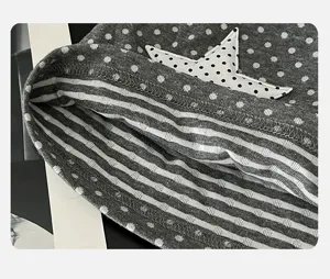 Detail shot of women slouchy hat fabric, featuring grey polka dots and striped inner lining.