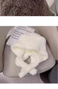 Detail view of a cozy white fluffy integrated bear ear hat and scarf for women in winter.