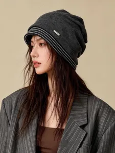 Stilisierte dunkelgraue Slouch Beanie Mütze mit weißen Streifen, ideal für Herbst u. Winter.