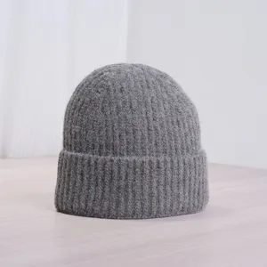 Gros plan détaillé d'un bonnet en tricot gris douillet, douce texture laine hivernale.