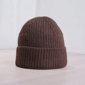 Gros plan d'un bonnet en tricot côtelé marron affichant une texture douce et un revers élégant.