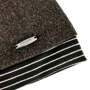 Braune Strickmütze Detailansicht, gestreifter Rippbündchen, Metallmarkenzeichen winter.