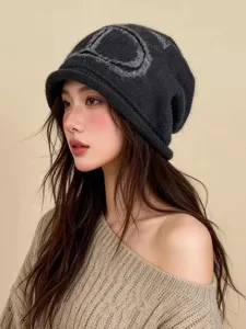 Gros plan d'un bonnet slouchy en tricot gris foncé avec bord roulé et motif élégant.