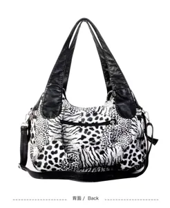 Detailed view of the black and white animal print women shoulder handbag with leather handles.