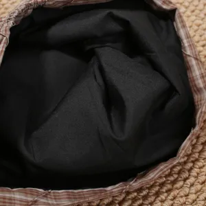 Vista detallada en primer plano del gorro slouchy de mujer con forro negro y borde de cuadros.