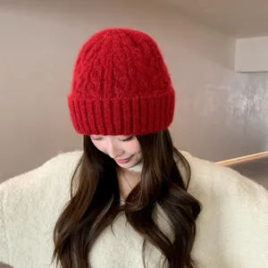 Primer plano detallado del acogedor gorro de punto rojo usado, textura de lana suave.