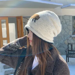 Detailansicht der niedlichen Strickmütze mit Schaf-Muster, kuscheliges Winteraccessoire.