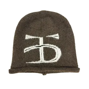 Détail de bonnet d'hiver en tricot marron, revers douillet et jolie broderie.