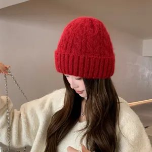 Primer plano de gorro de punto rojo llevado por modelo, textura suave y acogedora para invierno.