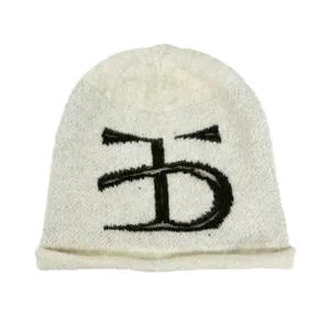 Vue détaillée d'un bonnet en tricot blanc cassé douillet avec un logo monogramme brodé en noir.