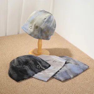 Detail view of retro tie-dye slouchy beanie hats featuring cute star pendants for women autumn winter.