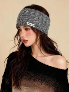 Primer plano de la cómoda diadema de punto gris con detalle de etiqueta, accesorio de invierno cálido.