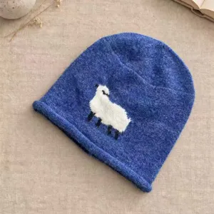 Nahaufnahme des niedlichen Schafmusters auf der kuscheligen blauen Strickmütze.