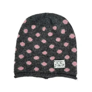 Nahaufnahme der kuscheligen dunkelgrauen Strickmütze mit pinken Punkten und Stofflabel.