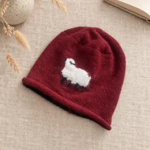 Nahaufnahme Detailansicht der süßen weißen Schaf Strickmütze, dunkler roter Winterwollhut.