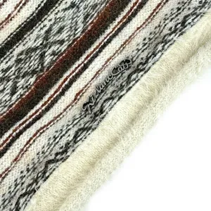 Detalle en primer plano del gorro de punto de felpa con textura suave y etiqueta metálica.