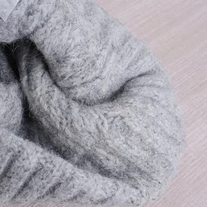 Primer plano detalle gorro punto trenzado gris, vista textura lana cálida invierno