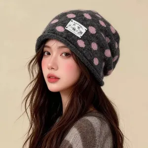 Modische graue Strickmuetze mit rosa Punkten und suessem Stoffaufnaeher fuer Damen